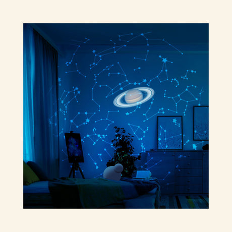Bedroom ceiling illuminated by the Thames & Kosmos Planetarium Projector, showing blue constellation patterns and a projected image of Saturn above the room.