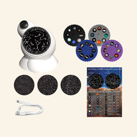 Thames & Kosmos Planetarium Projector kit contents showing the white projector, interchangeable image disks, star map domes, USB power cable, and instruction materials.