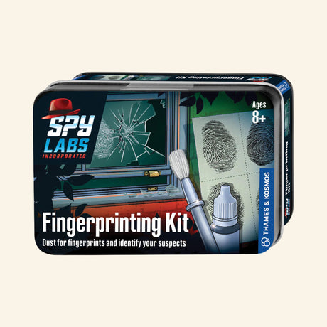 Thames & Kosmos Spy Labs: Fingerprinting Kit metal tin showing fingerprint powder, brush, lifted fingerprints, broken glass investigation artwork, and “Dust for fingerprints and identify your suspects” text.