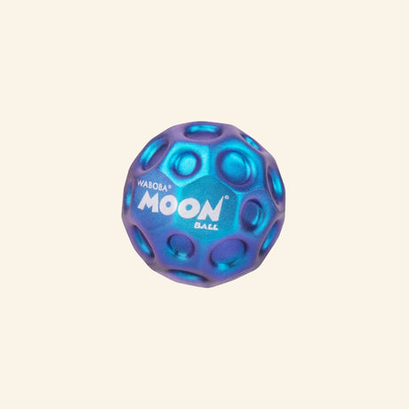 Waboba Metallic Moon Ball shown in a blue and purple iridescent finish with raised crater-like texture, circular grip details, and white Moon Ball logo on the front.