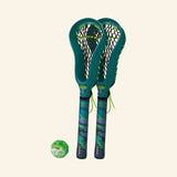 Waboba Moon Ball Mini Lacrosse – Urban LAX set with two matching green-and-blue mini lacrosse sticks standing upright and one mini Moon Ball placed beside them.